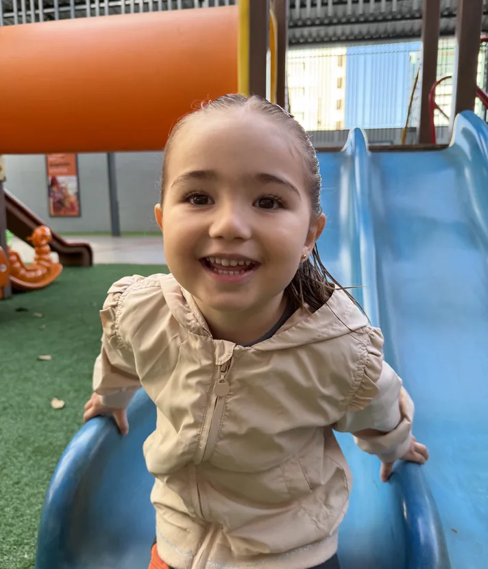 Aluna da Educação Infantil brincando no playground coberto do Colégio Criarte em Maringá
