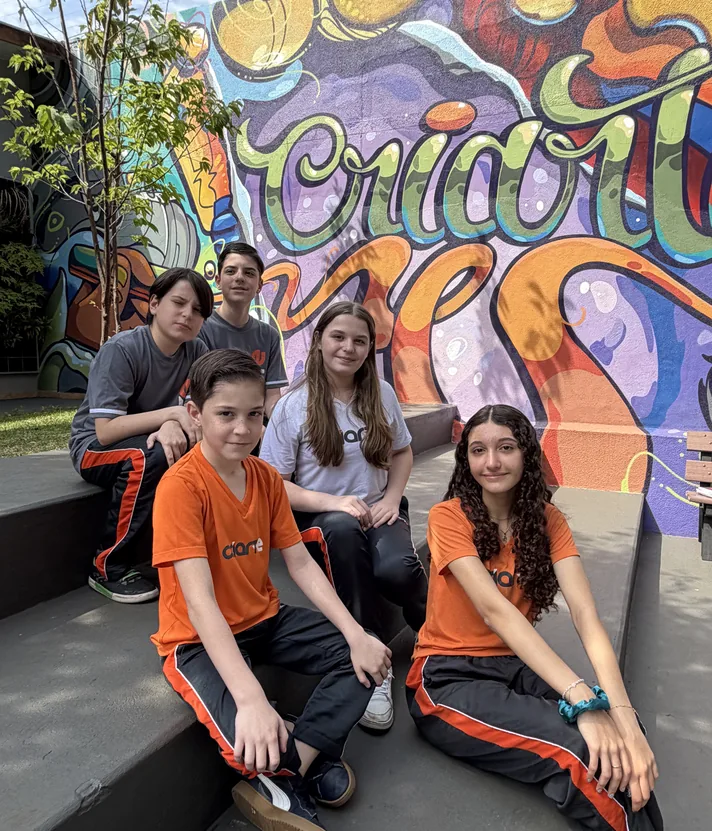 Turma do Ensino Fundamental reunida no mural grafitado do Colégio Criarte
