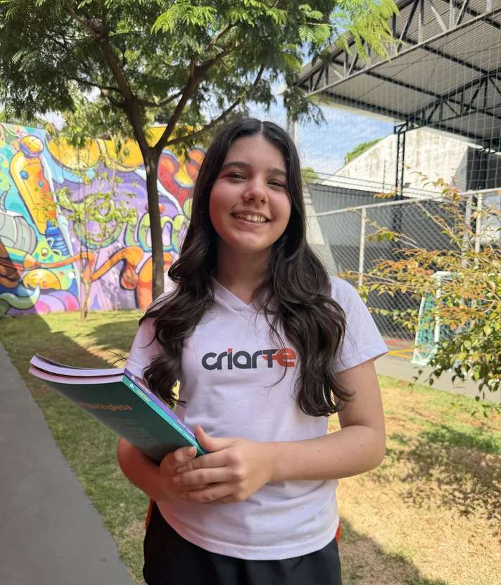 Aluna do Ensino Médio do Colégio Criarte com materiais de estudo