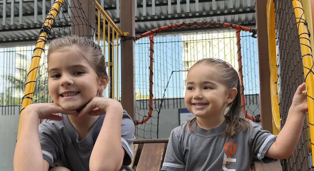 Alunas da Educação Infantil sorrindo no parque do Colégio Criarte