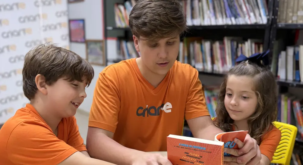 Alunos do Ensino Fundamental lendo juntos na biblioteca do Colégio Criarte